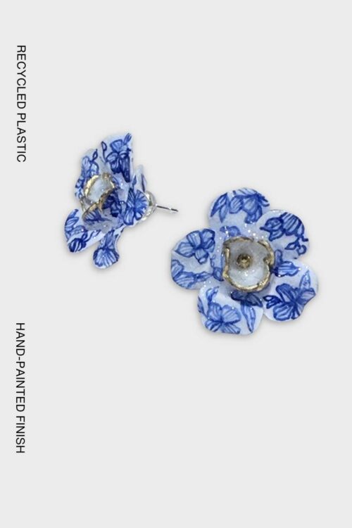 Handcrafted flower earrings made from recycled plastic, featuring blue-and-white porcelain-inspired floral patterns with hand-painted gold detailing.