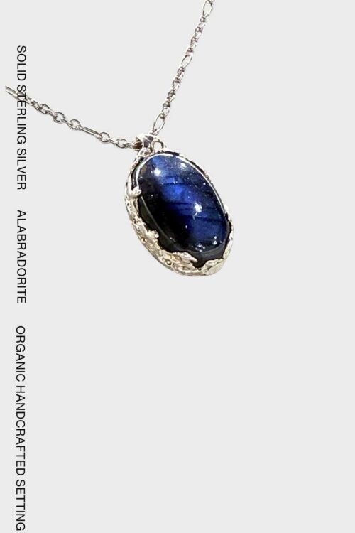 Handcrafted 925 sterling silver necklace featuring an oval natural labradorite gemstone with vivid blue iridescence in an organic silver setting.